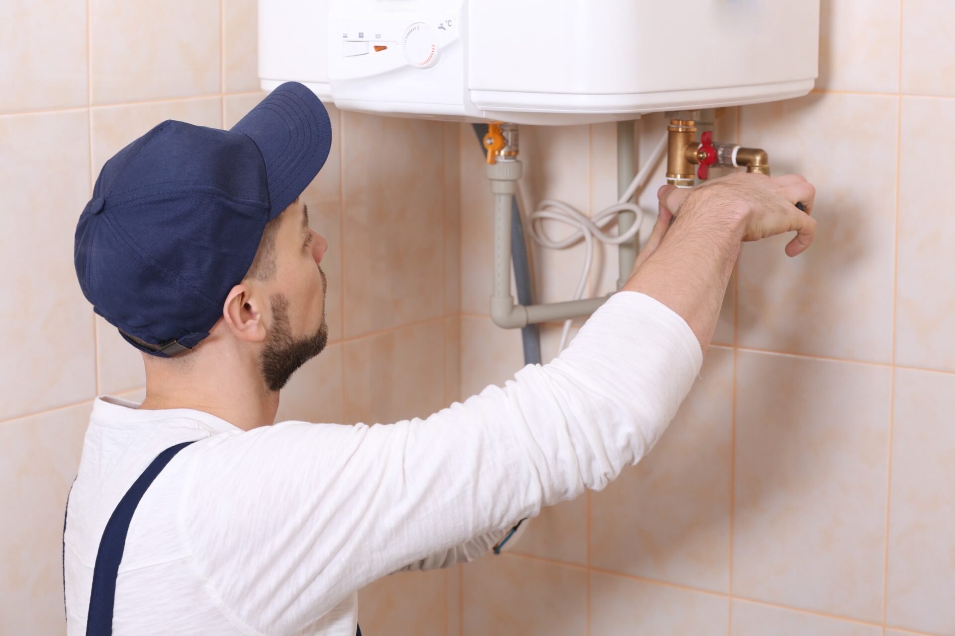 Plumber installing water heater in bathroom